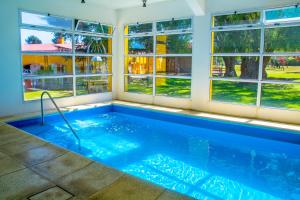 a swimming pool in a house with windows at Hotel Parque in Merlo
