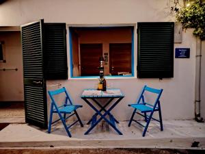 two blue chairs and a table in front of a building at Cavo Beach 6 in Cavo