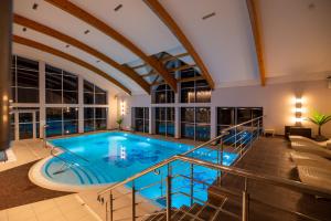 an indoor swimming pool with a large ceiling at Robson Beach I Sauna, Jacuzzi in Międzywodzie