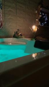 a bathroom with a tub with a green counter top at La cabane des amoureux du jardin in Barjols