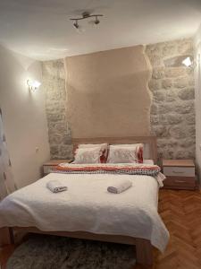 a bedroom with a bed with two slippers on it at Cozy Little House Kotor in Kotor