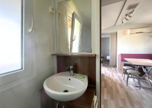 een badkamer met een wastafel, een spiegel en een tafel bij Del Falco AgriCamp-12 kilometers to Garda Lake and Verona in Bussolengo +39 foto's