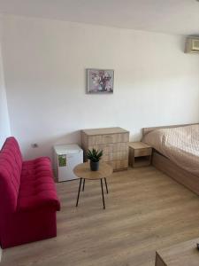 a living room with a red couch and a bed at Апартамент за гости ''ЗДРАВЕ'' in Kyustendil