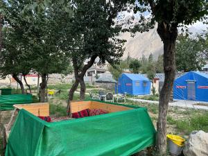 a group of tents in a field with a tree at Valhalla Guest House Skardu in Skardu +3 photos