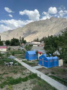 a small town with blue buildings and a mountain at Valhalla Guest House Skardu in Skardu