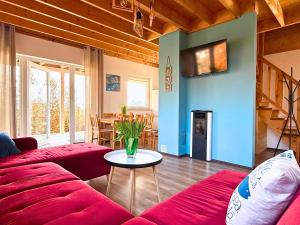 Una sala de estar con un sofá rojo y una mesa. en Morska Polana, en Mielno