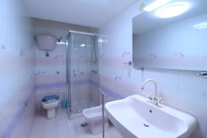 Un baño con lavabo, ducha e inodoro. en Casa Maria - Historic center, en Procida