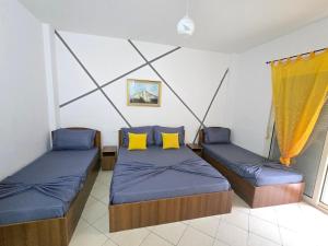 una camera con due letti con cuscini gialli di Bar Restorant Hotel “ MANI “ a Velipojë