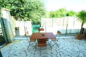 Una mesa y sillas de madera en un patio. en Casa Maria - Historic center, en Procida