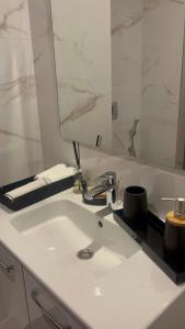Un baño con un lavabo blanco y un espejo. en Furnished studio with pool, en Nouaseur 10 fotos más