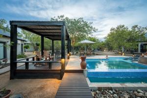 a swimming pool with a pavilion next to a house at The Baobab Bush Lodge in Hoedspruit