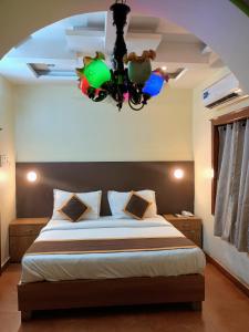 a bedroom with a bed and a chandelier at Kgb villa homes in Visakhapatnam
