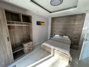 een slaapkamer met een bed en een houten wand bij Caz la plaz - Beach front apartment - 2BR in Flic-en-Flac