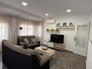 Una sala de estar con un sofá y un televisor. en Habitación cerca Murcia centro y Arrixaca, en Murcia