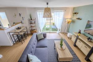 a living room with a blue couch and a table at Maisonnette à Mont-de-Marsan in Mont-de-Marsan
