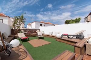 a backyard with a patio with green grass at Villa Tricia 6 Bedroom Las Americas in Playa de las Americas