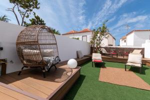 a garden with a bird cage and chairs on a deck at Villa Tricia 6 Bedroom Las Americas in Playa de las Americas