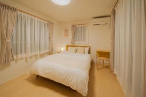 ein weißes Schlafzimmer mit einem Bett und einem Schreibtisch in der Unterkunft Magazine Home Tokyo Spacious 93 3BR Skytree7 minutesAsakusa12 minutes by train in Tokio