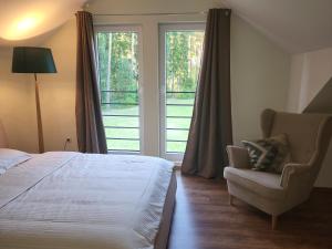 a bedroom with a bed and a chair and a window at Saules māja in Gāršmuiža +9 photos