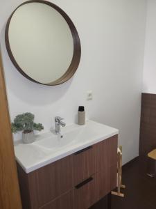 a bathroom with a sink and a mirror on the wall at Saules māja in Gāršmuiža