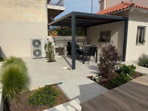 an outdoor patio with a table and a grill at Oikies in Astros +51 photos