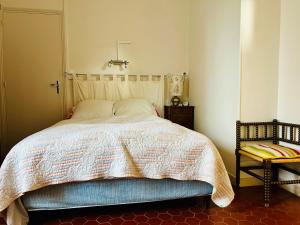 a bedroom with a bed and a lamp and a chair at Maison dans petit village du Morvan in Vieux-Château
