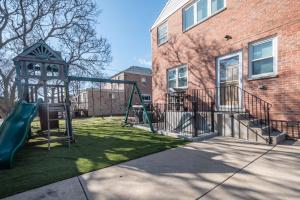 a playground in a yard next to a brick building at A Charming Modern Chic Basement Apartment in Chicago