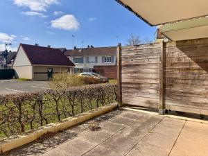 una recinzione di legno di fronte a una casa di A 2 pas du port de plaisance a Saint-Valéry-sur-Somme