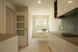 a kitchen with a table and a chair and a window at Beach House Castelldefels in Castelldefels