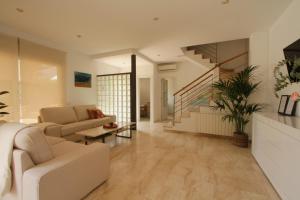a living room with a couch and a staircase at Beach House Castelldefels in Castelldefels