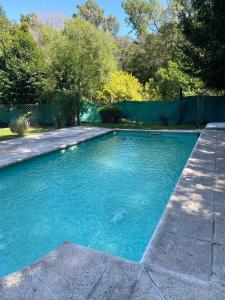 a swimming pool with blue water in a yard at Hotel y Cabañas Gran Cordoba in La Falda