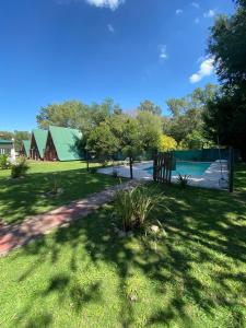 a yard with a fence and a swimming pool at Hotel y Cabañas Gran Cordoba in La Falda