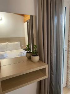 una camera da letto con un letto con due piante su una mensola di Milos Apartments a Himare