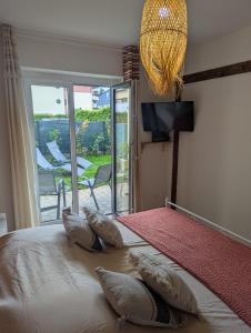 a bedroom with a bed with three pillows on it at Élégant et calme avec clim et jardin privé - Appartement Terracotta in Thonon-les-Bains