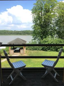 two chairs on a porch with a view of a lake at Villa Wieck am See, mit Ruderboot in Gransee
