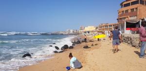 a group of people on a beach with the ocean at Residence Les Calanques in Dakar