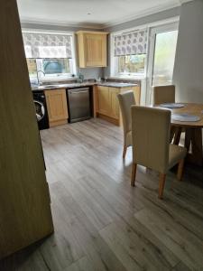 a kitchen with a table and chairs and a dining room at The Cottage in Kirk of Shotts