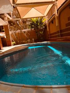 a swimming pool with an umbrella and blue water at Magic Studio Pool View, New Cairo in Cairo
