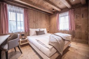 Ένα ή περισσότερα κρεβάτια σε δωμάτιο στο Ciasa Somuer