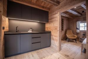 Una cocina con gabinetes negros y un fregadero. en Ciasa Somuer, en San Vigilio Di Marebbe