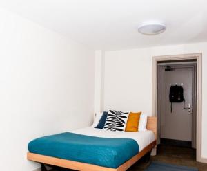 una camera da letto con un letto con cuscini colorati di KVM Lodge a Peddapalli