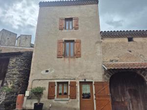 a building with two windows and a door at Au Pied des Remparts in Villeneuve
