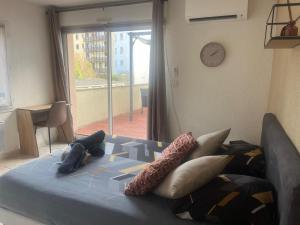 une chambre avec un lit avec des oreillers et une fenêtre dans l'établissement Rare en centre ville, studio climatisé avec terrasse XXL, à Tarbes