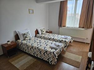 a hotel room with two beds and a window at Cтаи за гости Бърдареви in Bansko +47 photos