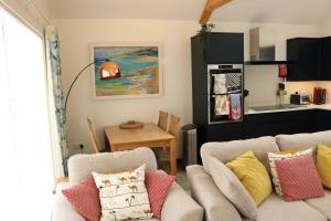 a living room with a couch and a kitchen at Luxury 2 bedroom property in quiet location close to SW Coastal Path in Paignton