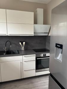 a kitchen with white cabinets and a sink at Ferienwohnung an der Warte in Waldeck