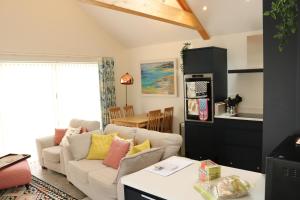 a living room with a couch and a kitchen at Luxury 2 bedroom property in quiet location close to SW Coastal Path in Paignton