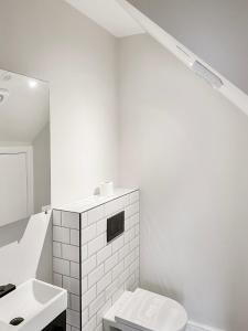 a white bathroom with a toilet and a sink at The Spa Nook with Hot Tub, Sauna and Room for 8 in East Barnet