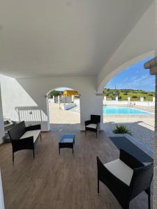 a living room with chairs and a swimming pool at Budoni residence Lutturai 4 in Budoni