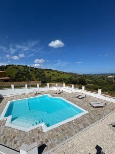 a large swimming pool with chairs at Budoni residence Lutturai 4 in Budoni +17 photos